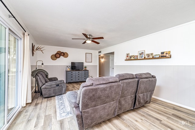 412 E Holmes Ave, Bronte, TX 76933 - living area with ceiling fan, light wood-type flooring, a wainscoted wall, and ornamental molding
