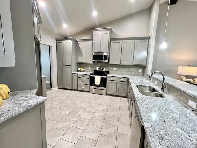 kitchen with gray cabinets, pendant lighting, sink, stainless steel appliances, and light stone countertops