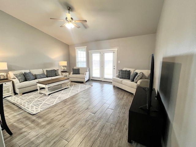 living room with ceiling fan, lofted ceiling, and hardwood / wood-style floors