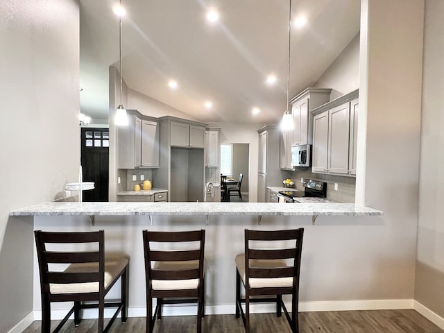 kitchen featuring vaulted ceiling, gray cabinetry, decorative backsplash, kitchen peninsula, and stainless steel appliances