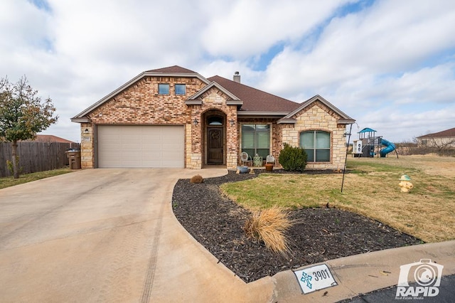 view of front of property with a garage, a playground, and a front yard