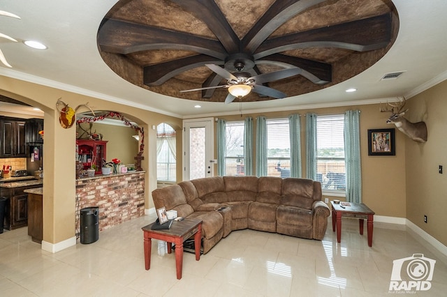 living room featuring ceiling fan, ornamental molding, a raised ceiling, and light tile patterned floors