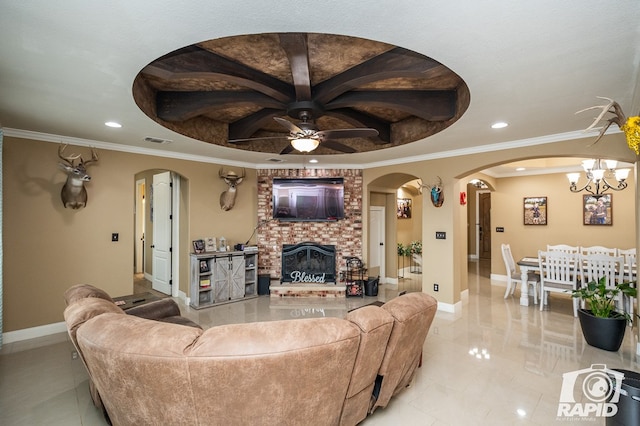 living room with a raised ceiling, crown molding, ceiling fan with notable chandelier, and a fireplace