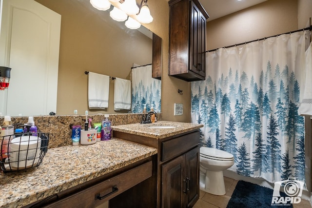 bathroom with a notable chandelier, vanity, tile patterned floors, and toilet