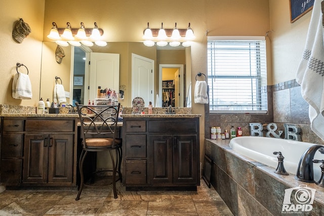 bathroom featuring vanity and tiled tub