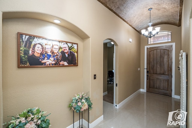 entryway with vaulted ceiling and a notable chandelier