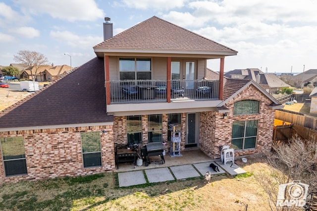 rear view of house featuring a patio and a balcony