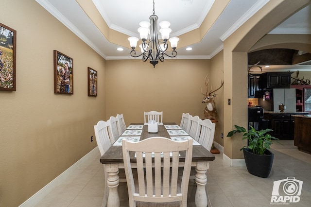 tiled dining room featuring crown molding, a raised ceiling, and a chandelier