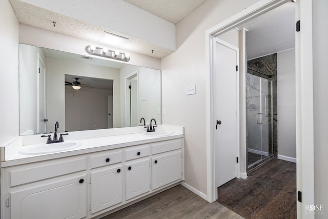 bathroom with walk in shower, a textured ceiling, vanity, ceiling fan, and hardwood / wood-style floors