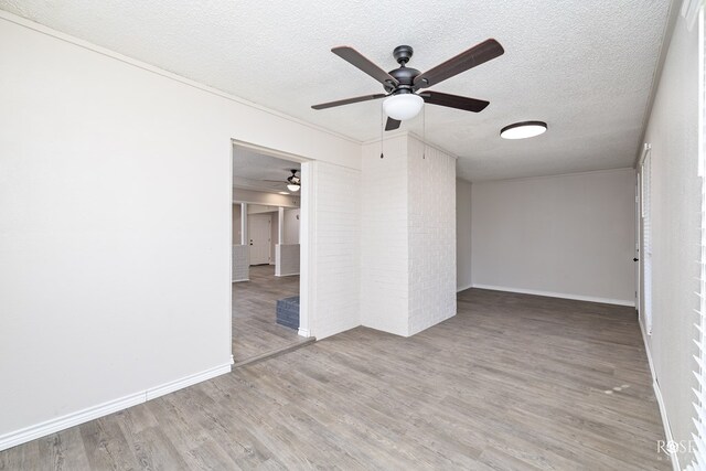 empty room featuring crown molding, a textured ceiling, and light hardwood / wood-style floors