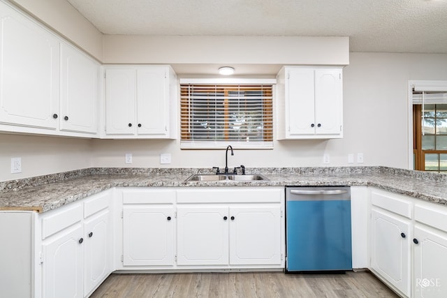 kitchen featuring sink, stainless steel dishwasher, white cabinets, and a textured ceiling