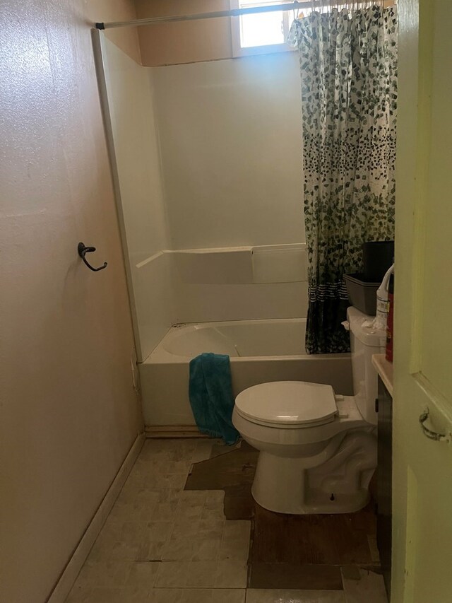 bathroom with shower / bathtub combination with curtain and toilet