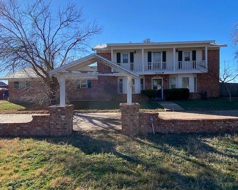 view of front of house with a front lawn and a balcony