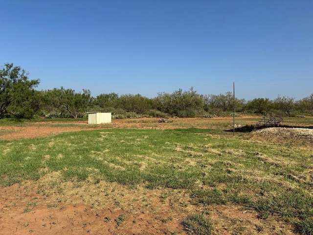 view of yard with a rural view and a storage shed