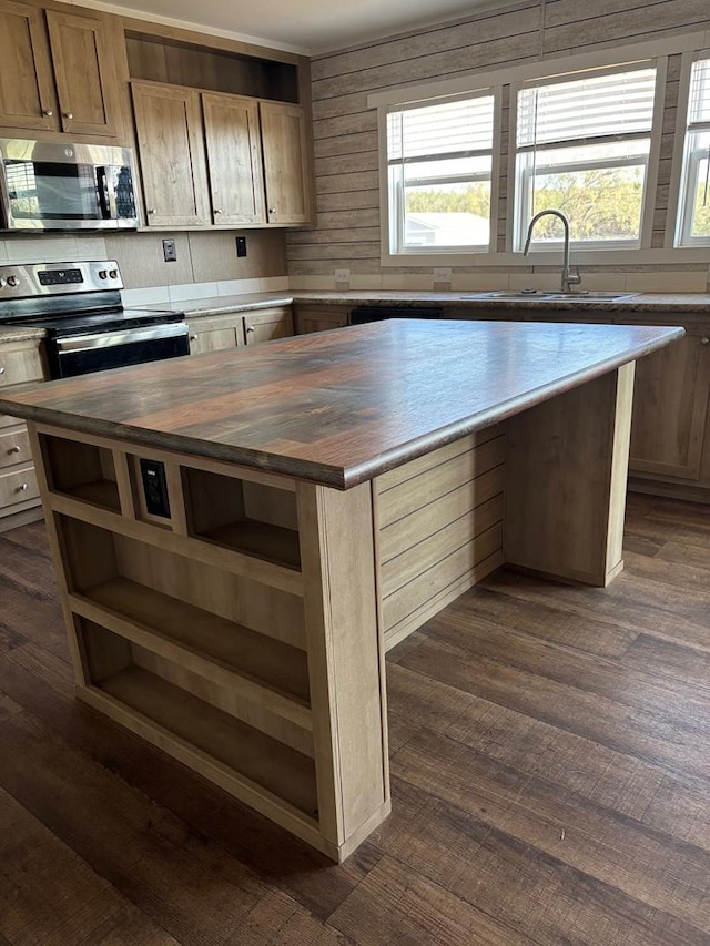 kitchen featuring butcher block countertops, sink, a center island, and appliances with stainless steel finishes