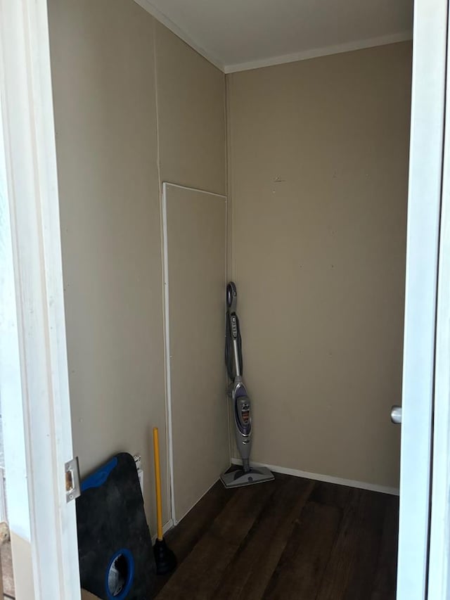 laundry area with crown molding and dark hardwood / wood-style floors