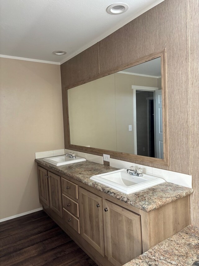 bathroom featuring hardwood / wood-style flooring, crown molding, and vanity