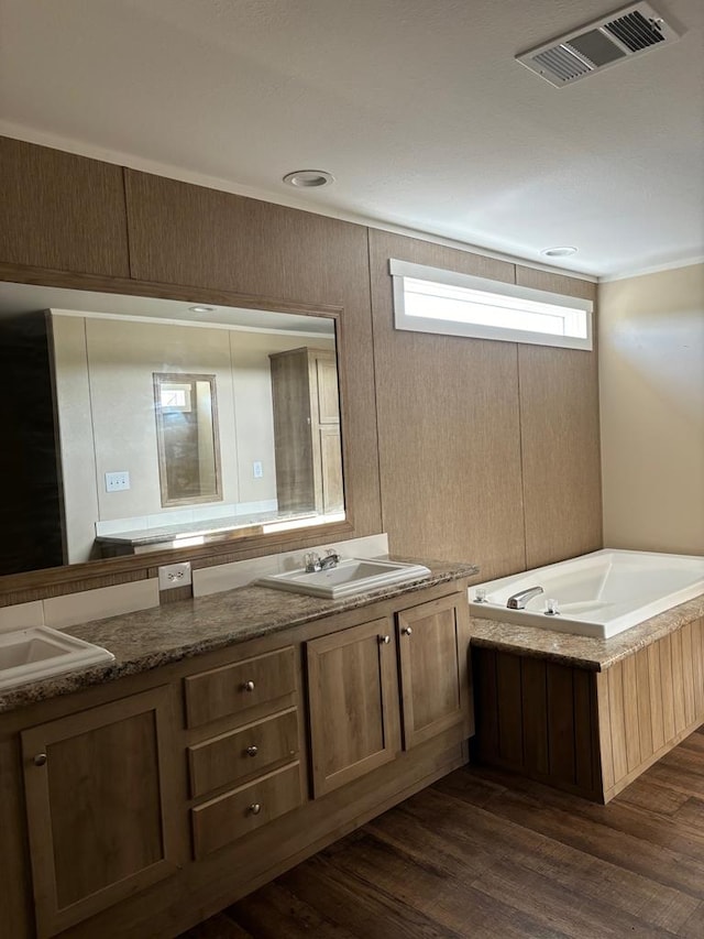 bathroom with vanity, hardwood / wood-style floors, and a tub