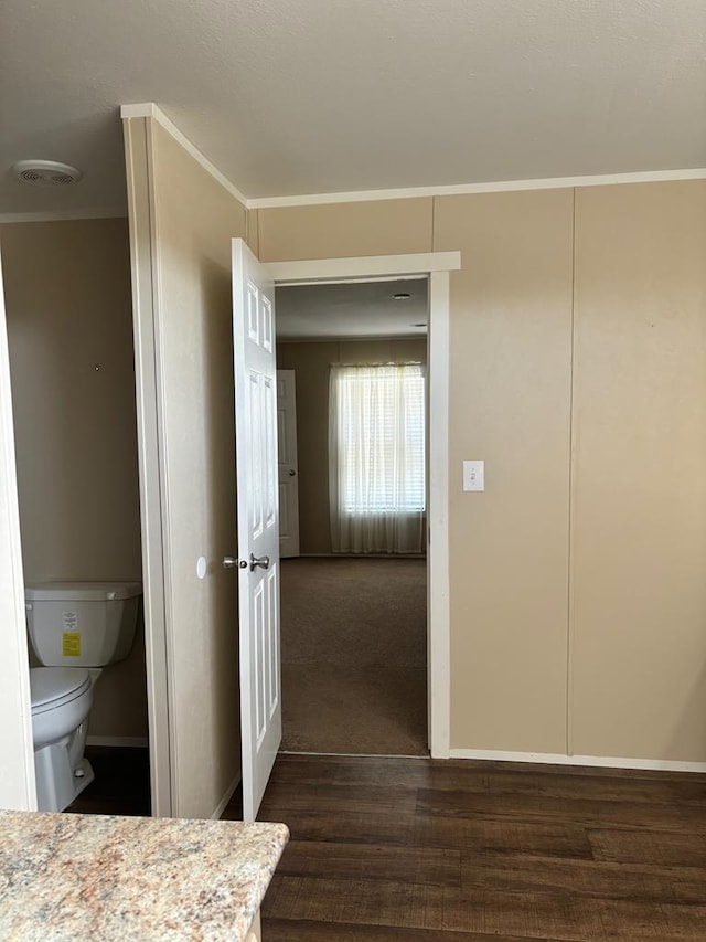 bathroom with crown molding, toilet, and hardwood / wood-style floors