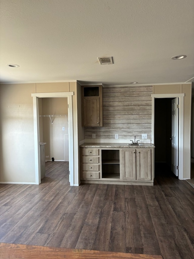 kitchen with dark hardwood / wood-style flooring, light brown cabinetry, sink, and a textured ceiling