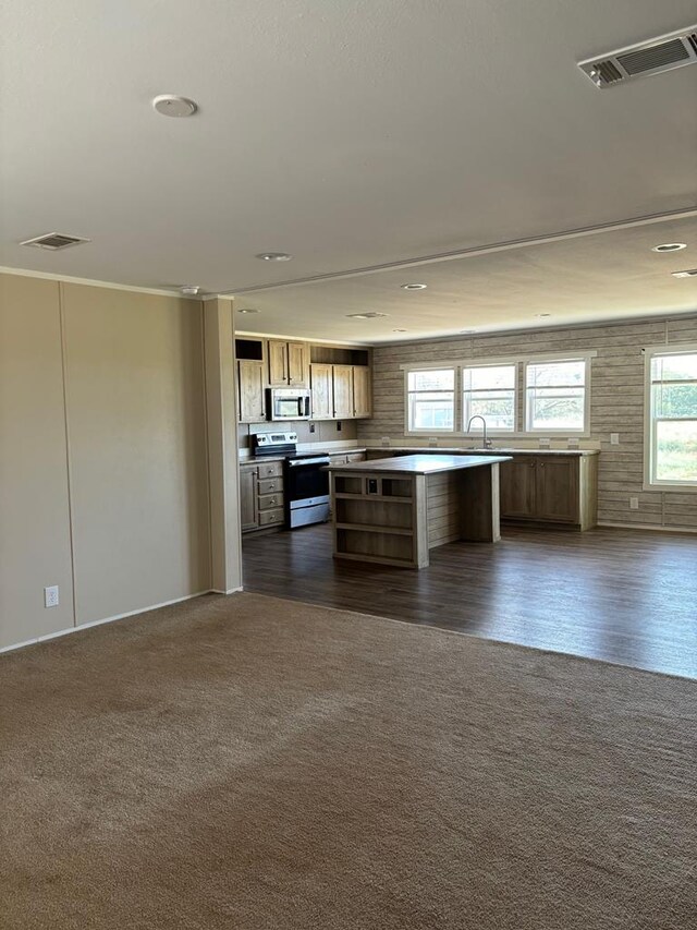 kitchen with stainless steel appliances, a center island, sink, and dark colored carpet