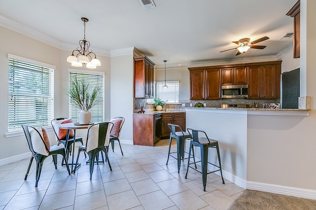 4333 Chisholm Trl, San Angelo, TX 76903 - kitchen featuring stainless steel microwave, backsplash, a ceiling fan, pendant lighting, and a peninsula