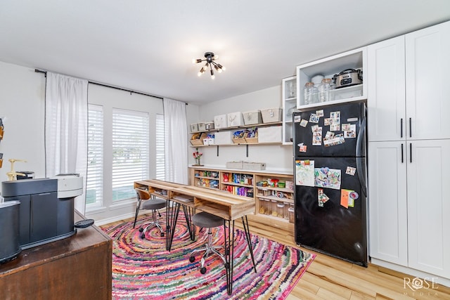 home office with light hardwood / wood-style flooring