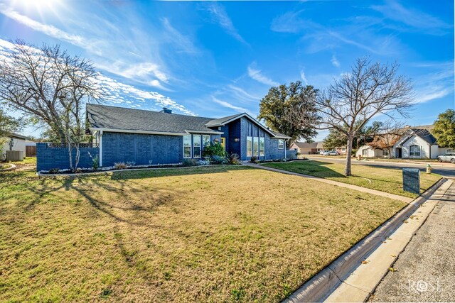 ranch-style home featuring central AC and a front lawn