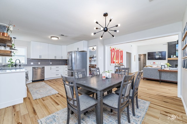 dining area featuring a notable chandelier and light wood-type flooring