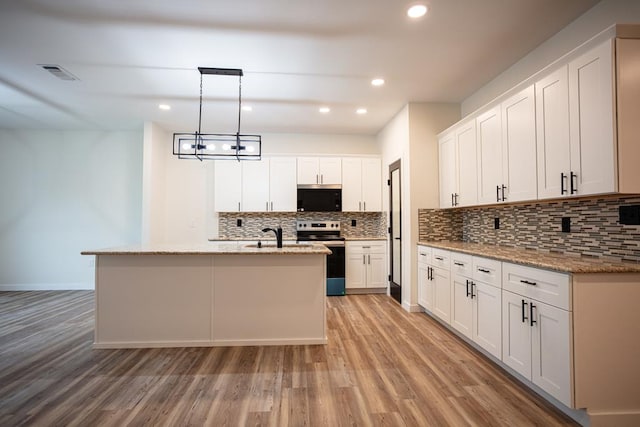 kitchen featuring visible vents, stainless steel electric stove, white cabinets, and pendant lighting