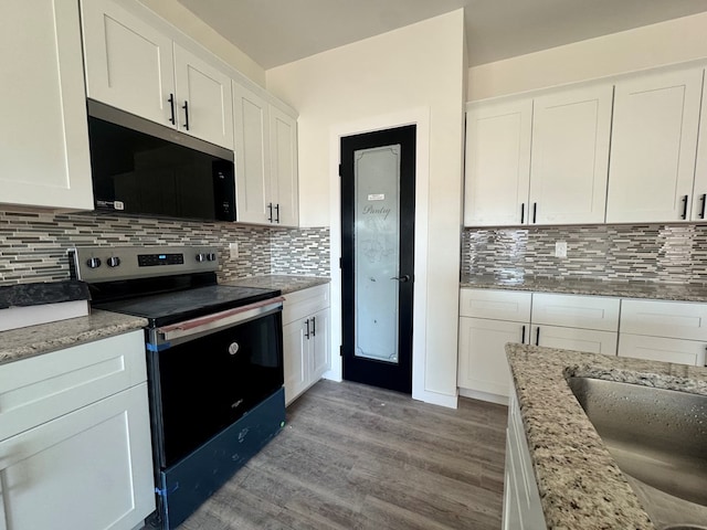 kitchen featuring white cabinetry, light wood-style floors, light stone countertops, tasteful backsplash, and stainless steel range with electric stovetop