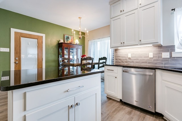 kitchen featuring white cabinetry, decorative light fixtures, stainless steel dishwasher, and decorative backsplash