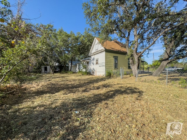 901 S Walnut St, Brady, TX 76825 - view of side of property with fence, a storage unit, and an outbuilding