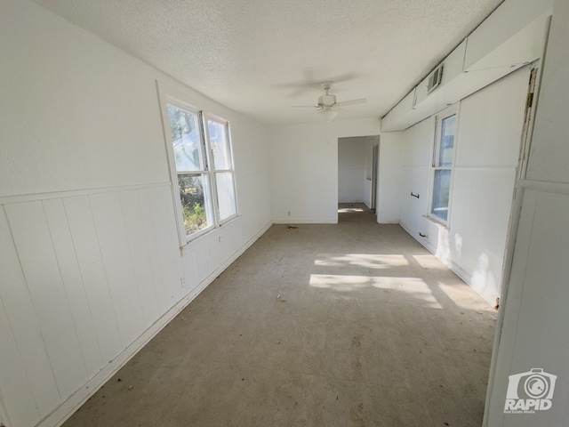 901 S Walnut St, Brady, TX 76825 - unfurnished room with a ceiling fan, a textured ceiling, and wainscoting