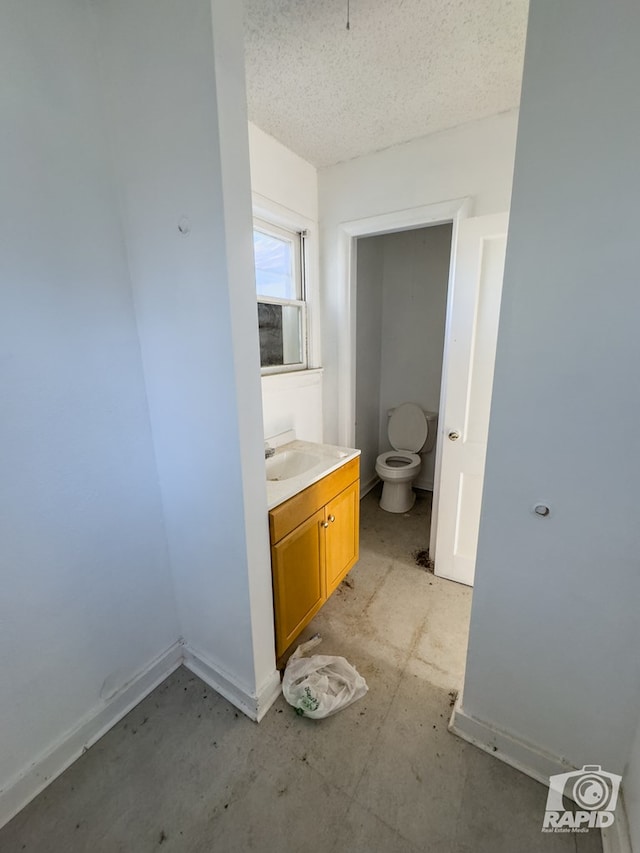 901 S Walnut St, Brady, TX 76825 - bathroom featuring toilet, baseboards, vanity, and concrete floors