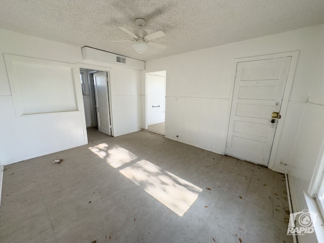 901 S Walnut St, Brady, TX 76825 - unfurnished bedroom featuring a textured ceiling and a ceiling fan
