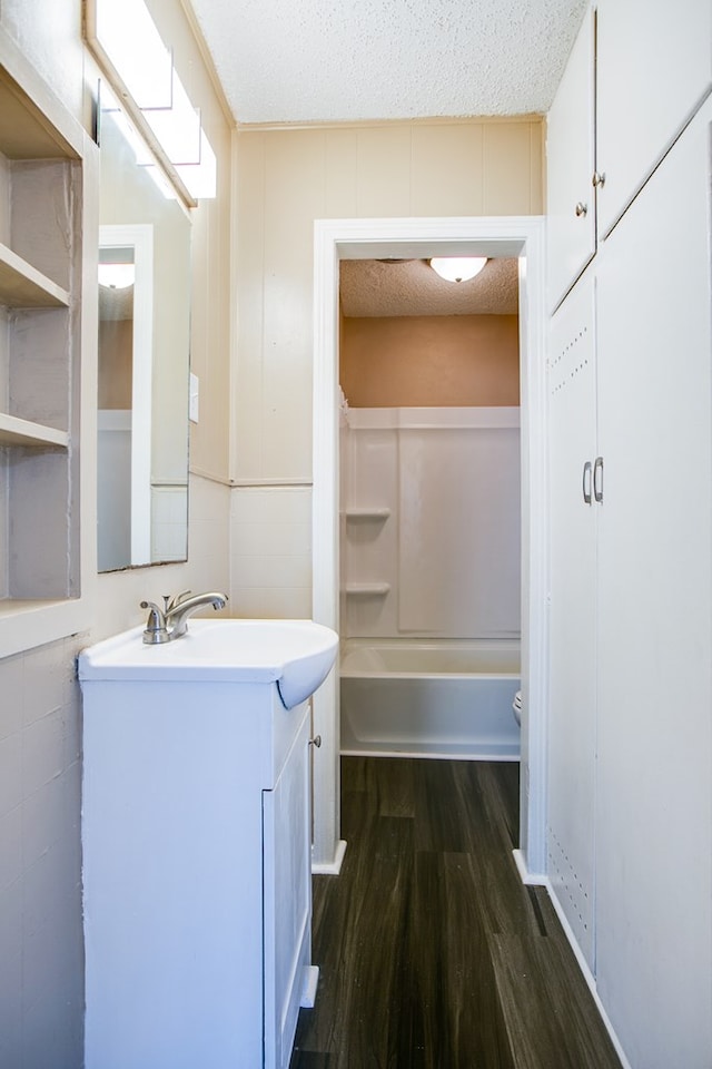 1619 Spaulding St, San Angelo, TX 76905 - full bath with vanity, wood finished floors, a textured ceiling, and tub / shower combination