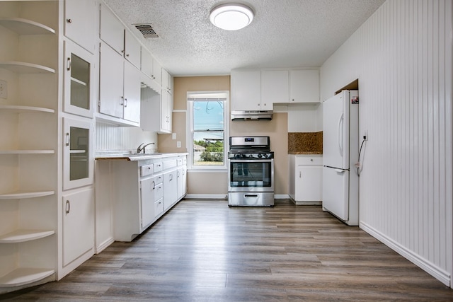 1619 Spaulding St, San Angelo, TX 76905 - kitchen featuring stainless steel range, freestanding refrigerator, under cabinet range hood, wood finished floors, and white cabinets