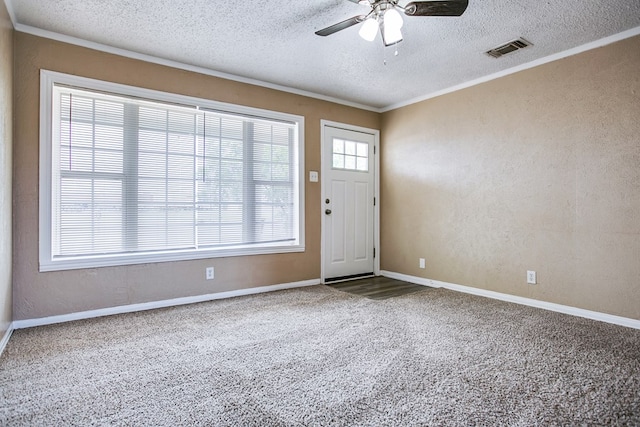 1619 Spaulding St, San Angelo, TX 76905 - carpeted foyer featuring a textured ceiling, ornamental molding, a ceiling fan, and a textured wall