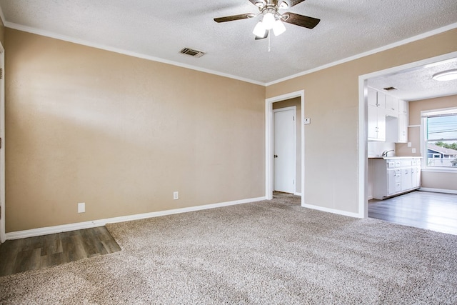 1619 Spaulding St, San Angelo, TX 76905 - carpeted empty room featuring a textured ceiling, ceiling fan, ornamental molding, and wood finished floors