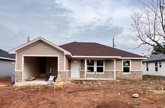 313 E 25th St, San Angelo, TX 76903 - view of front of property with brick siding, covered porch, and roof with shingles
