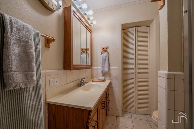 bathroom with tile walls, vanity, ornamental molding, toilet, and tile patterned floors