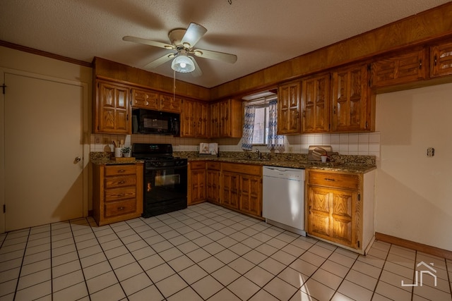 kitchen with sink, a textured ceiling, ceiling fan, dark stone counters, and black appliances