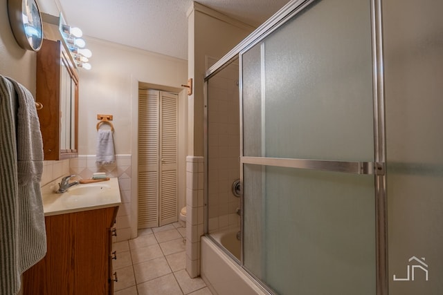 full bathroom with tile patterned floors, shower / bath combination with glass door, tile walls, a textured ceiling, and vanity