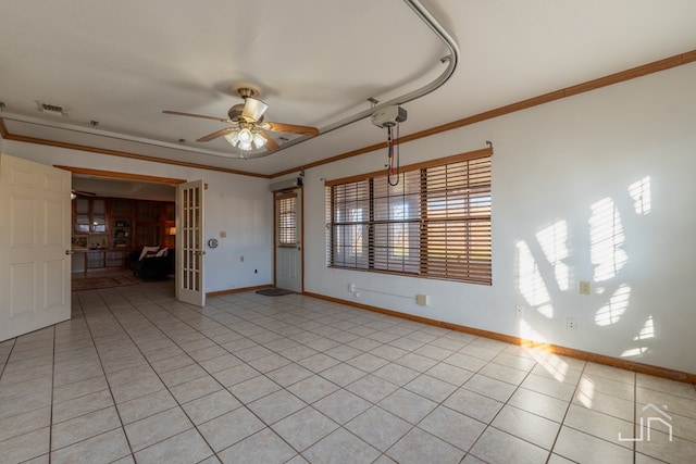 tiled empty room featuring french doors, ceiling fan, and ornamental molding