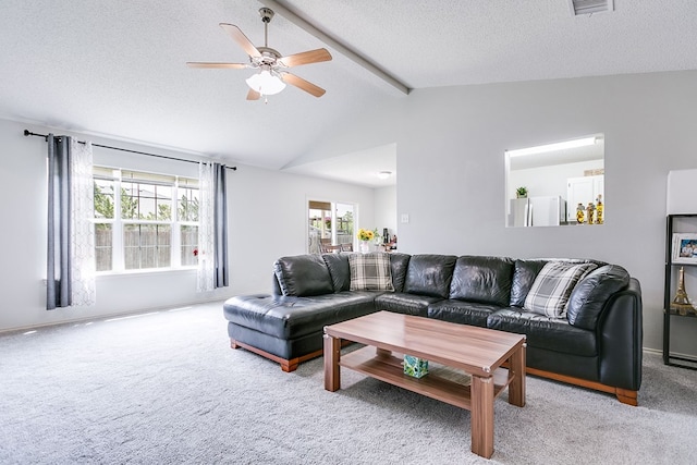 living room featuring lofted ceiling with beams, carpet floors, visible vents, a ceiling fan, and a textured ceiling