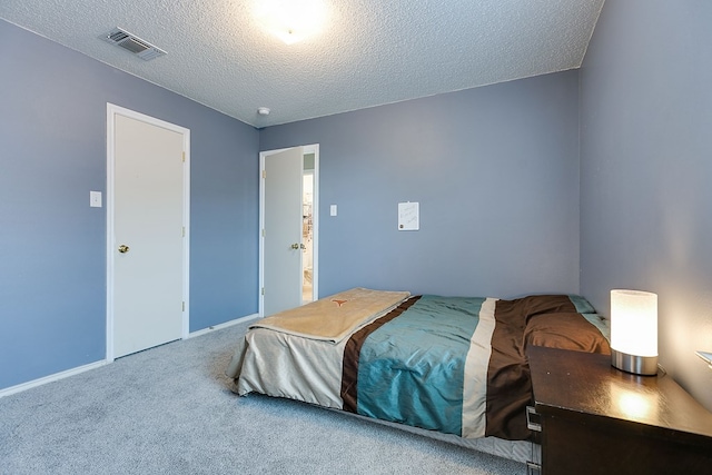 bedroom featuring a textured ceiling, visible vents, carpet, and baseboards