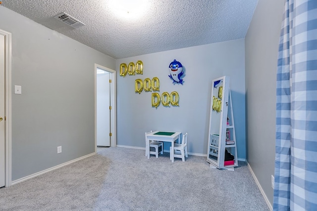 playroom with baseboards, visible vents, a textured ceiling, and carpet floors