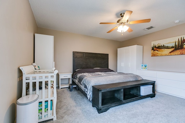 bedroom with light colored carpet, visible vents, and a ceiling fan