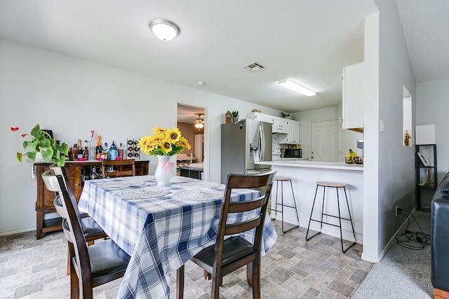 dining space with baseboards, visible vents, and stone finish floor